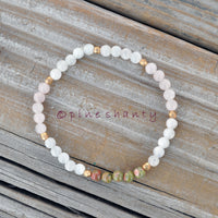 Beaded bracelet with white and multicolored beads on a wooden surface, branded 'pineshanty'.