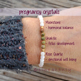 Beaded bracelet on a wrist with pregnancy crystal information